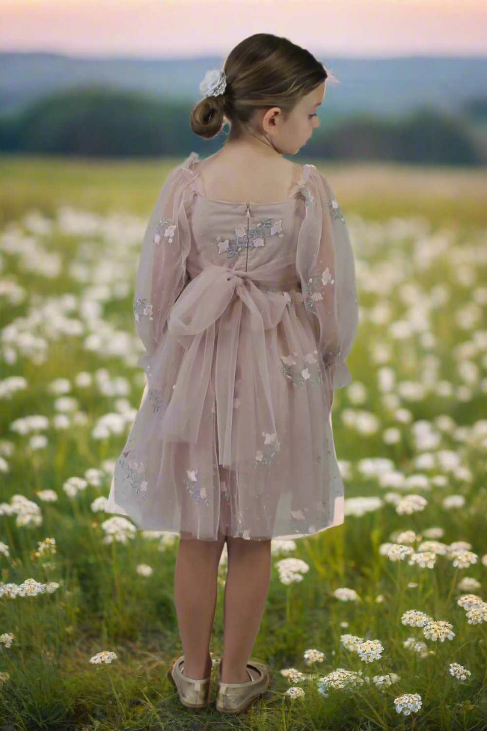 back of dress with a tulle bow sash. Champagne flower girl dress with long sleeve tulle sleeves. made with a tulip embroidery flower and swiss dot pattern.