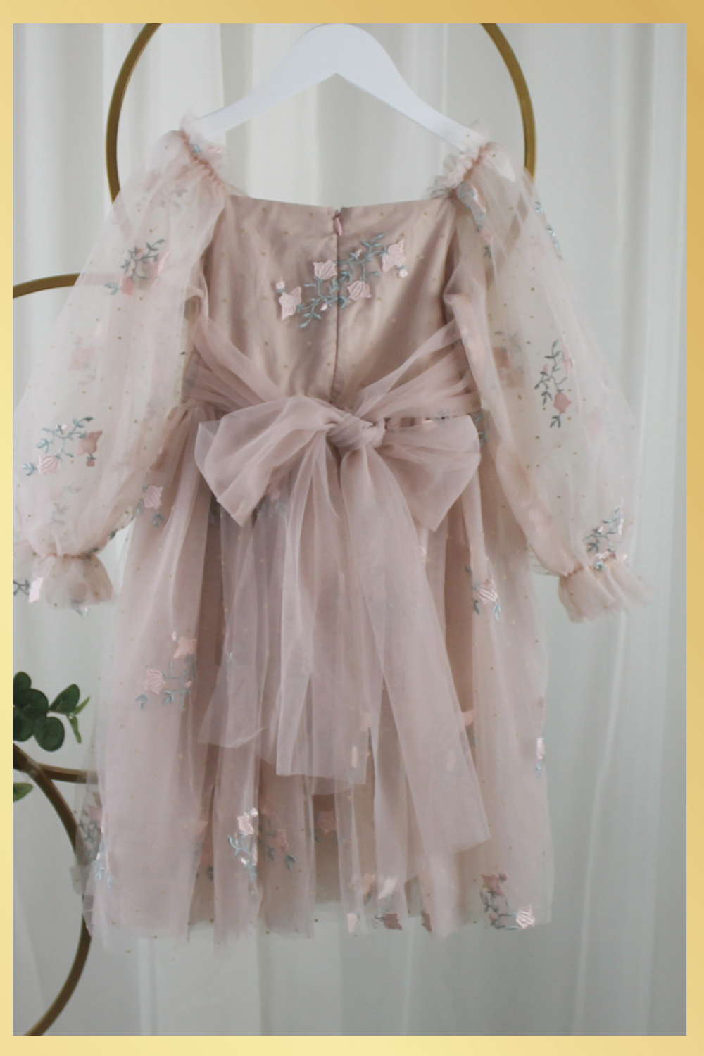 Back of dress. With zipper and tulle sash tied in a bow. Champagne flower girl dress with long sleeve tulle sleeves. made with a tulip embroidery flower and swiss dot pattern.
