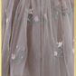 Close up of champagne tulle with swiss dot pater, and tulip embroidered flower and greenery. 