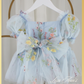 Back of dress showing a tulle floral tied bow. Dress made with built in bodysuit and a light blue floral tulle print on dress. 