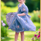floral dress in dusty blue tulle with embroidered flowers and butterflies all over the dress. In a puff sleeve and knee length style. Prefect for an upcoming wedding or birthday. 