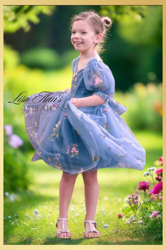 floral dress in dusty blue tulle with embroidered flowers and butterflies all over the dress. In a puff sleeve and knee length style. Prefect for an upcoming wedding or birthday. 