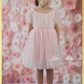flower girl dress in a light pink swiss dot pattern. Puff short sleeves and knee length style. 